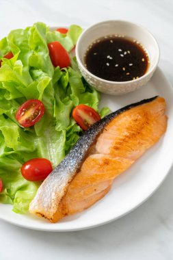 Kızarmış somon bifteği ve sebze salatası. Sağlıklı yemek tarzı.