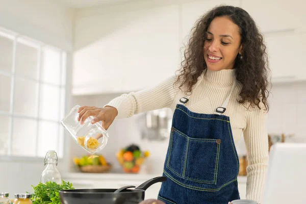 Latin kadın blogda paylaşmak için mutfakta video ve yemek çekiyor.