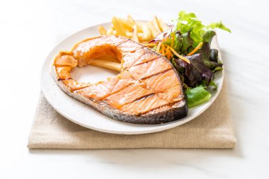 Kızarmış somon bifteği fileto, sebze ve patates kızartması.