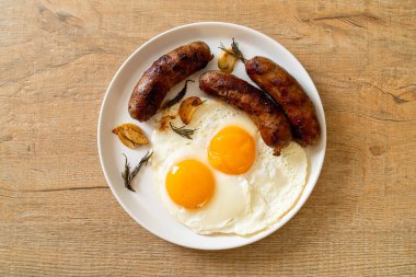 Kahvaltıda omlet ve kızarmış domuz sosisi.