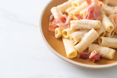 Beyaz soslu ve pastırmalı ev yapımı spagetti rigatoni makarna. İtalyan usulü.