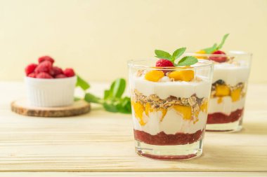 Ev yapımı taze mango ve yoğurt ve granola ile taze ahududu. Sağlıklı yemek tarzı.