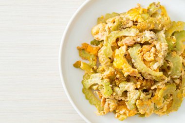 Kızarmış acı kabağı tabakta yumurta ile karıştır