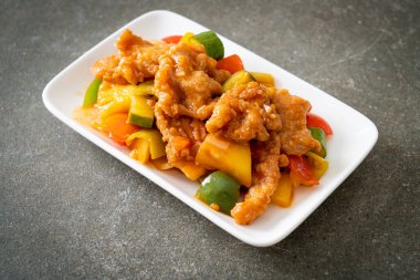 Kızarmış tatlı ve ekşi sosla domuz ve sebzeyi karıştır.