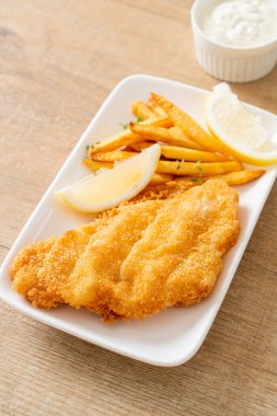 balık ve patates kızartması - kızarmış balık fileto patates cipsi ve limonlu beyaz tabak