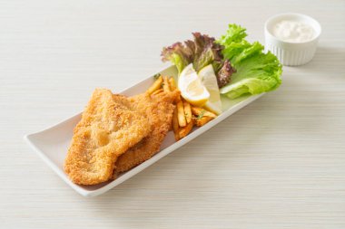 balık ve patates kızartması - kızarmış balık fileto patates cipsi ve limonlu beyaz tabak