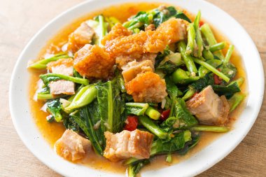 Kızarmış lahana sebzesi ve kıtır domuz eti Asya yemeği.