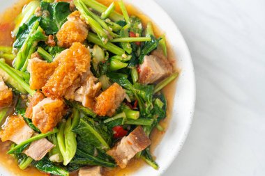 Kızarmış lahana sebzesi ve kıtır domuz eti Asya yemeği.