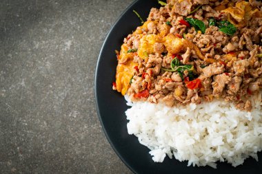 Pirinçli yumurta ve fesleğenli kızarmış domuz eti. Asya usulü.