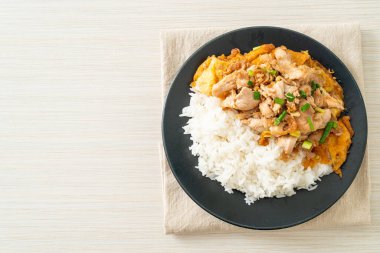 Pirinç üzerine sarımsak ve yumurta soslu kızarmış domuz eti. Asya usulü.