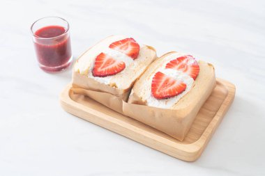 gözlemeli sandviç, çilekli taze krema, ahşap tabakta.