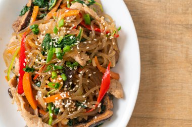 Japchae ya da karışık Kore vermicelli erişte sebzeli ve üzerine beyaz susamlı domuz eti - Kore geleneksel yemek tarzı