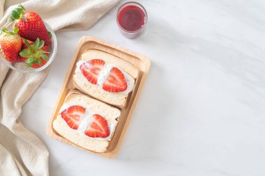 gözlemeli sandviç, çilekli taze krema, ahşap tabakta.