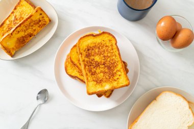 Kahvaltı için beyaz tabakta yumurtalı ekmek.