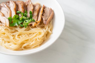 Beyaz kasede pişmiş ördekle kurutulmuş şehriye. Asya usulü.