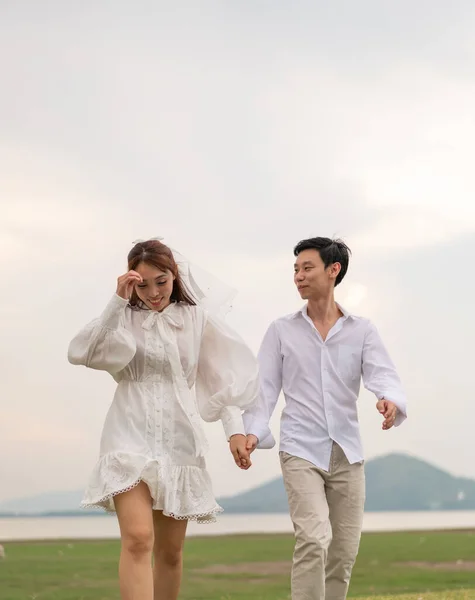 Happy young Asian couple in bride and groom clothing ready for marry and wedding celebrate