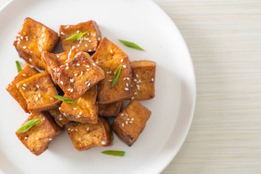 Beyaz susamlı kızarmış tofu ve teriyaki sosu. Vejetaryen ve vejetaryen yemek tarzı.