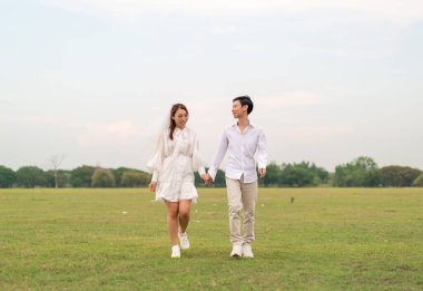 Gelin ve damat kıyafetli mutlu genç Asyalı çift evlenmeye ve evlenmeye hazır.