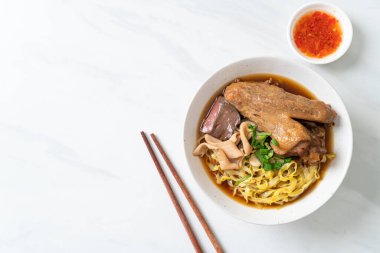 Kahverengi çorbada haşlanmış ördek ve haşlanmış yumurtalı şehriye Asya yemeği.