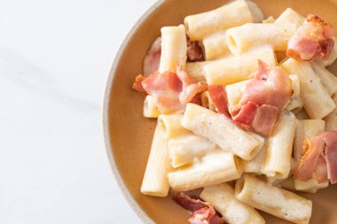 Beyaz soslu ve pastırmalı ev yapımı spagetti rigatoni makarna. İtalyan usulü.