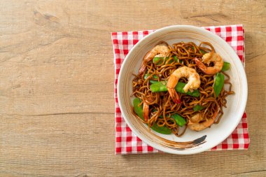 Kızarmış yakisoba eriştesi, yeşil bezelye ve karides, Asya usulü.