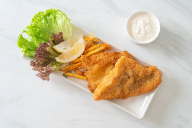 balık ve patates kızartması - kızarmış balık fileto patates cipsi ve limonlu beyaz tabak