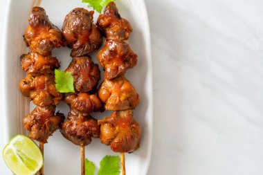 Izgara tavuk şişi. Tabakta baharat ve şifalı otlar var.