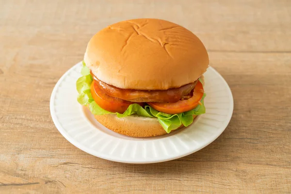 chicken burger with sauce on white plate
