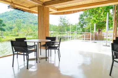 Restoranda boş masa ve sandalye doğa manzaralı.