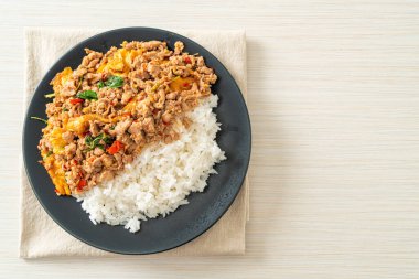 Pirinçli yumurta ve fesleğenli kızarmış domuz eti. Asya usulü.