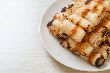 Izgara tüp şeklinde balık ezmeli kek ya da tabakta mürekkep balığı şişi.