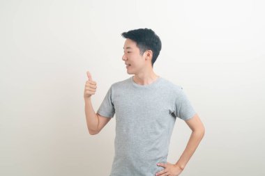 Beyaz arka planda eli işaret eden ya da sunan genç Asyalı adam portresi