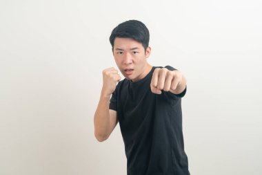 Beyaz arka planı yumruklayan genç Asyalı adam.