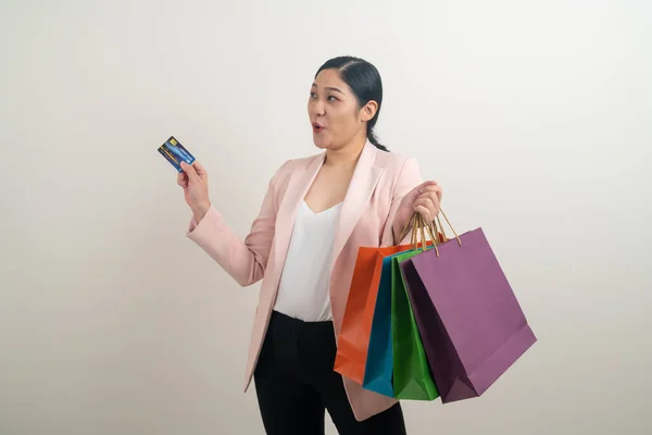 白い背景を持つ手にショッピングバッグやクレジットカードを持つアジアの女性 — ストック写真
