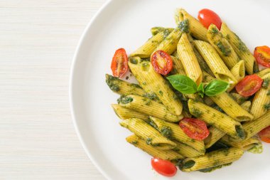 Pesto soslu ve domatesli makarna. Vejetaryen ve vejetaryen yemek tarzı.