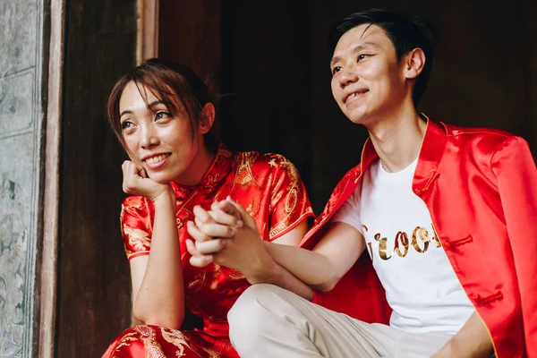 Mutlu genç Asyalı çiftler geleneksel Çin elbiseleriyle sevişir. Kırmızı, geleneksel bayramın ana rengidir. Buna Çin 'de düğün de dahil..