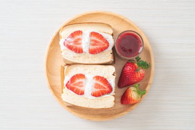 gözlemeli sandviç, çilekli taze krema, ahşap tabakta.