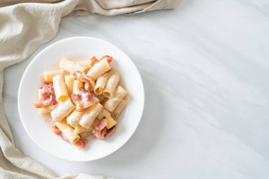 Beyaz soslu ve pastırmalı ev yapımı spagetti rigatoni makarna. İtalyan usulü.