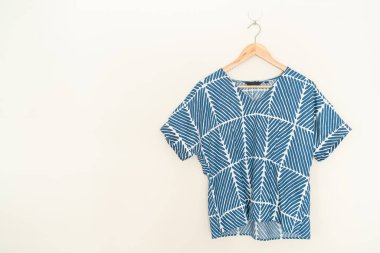 tie dye shirt hanging with wood hanger on wall