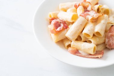 Beyaz soslu ve pastırmalı ev yapımı spagetti rigatoni makarna. İtalyan usulü.