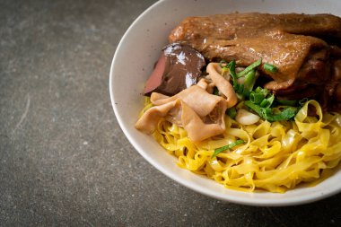 Yumurtalı erişte, kurutulmuş ördekle servis edilir. Asya usulü.