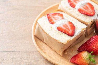 gözlemeli sandviç, çilekli taze krema, ahşap tabakta.