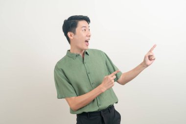 Beyaz arka planda eli işaret eden ya da sunan genç Asyalı adam portresi