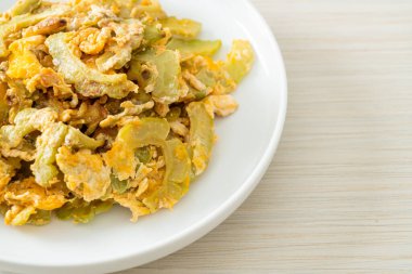 Kızarmış acı kabağı tabakta yumurta ile karıştır