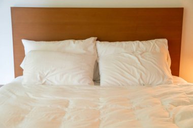 Yatak odasındaki beyaz yastık süslemesi