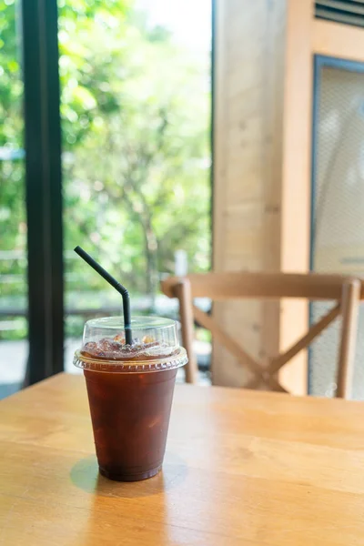 iced americano black coffee in takeaway glass on table in coffee shop cafe restaurant