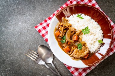 Dilimlenmiş domuz eti, havuç ve soğanlı Japon körili pilavı. Asya usulü.