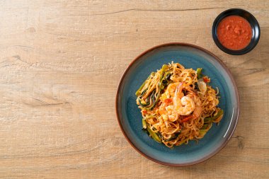 Karıştırılmış hazır erişteli sukiyaki, karidesli, Asya usulü.