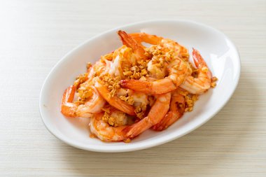 Kızarmış karides ya da beyaz tabakta sarımsaklı karides - deniz ürünleri tarzı.