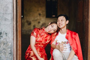 Mutlu genç Asyalı çiftler geleneksel Çin elbiseleriyle sevişir. Kırmızı, geleneksel bayramın ana rengidir. Buna Çin 'de düğün de dahil..